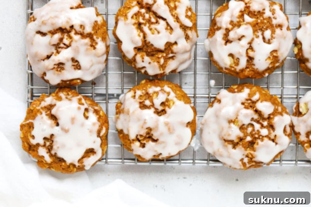 Cozy Fall Gluten-Free Pumpkin Snickerdoodles 9 Vanilla glazed gluten-free pumpkin oatmeal cookies on a wire rack.