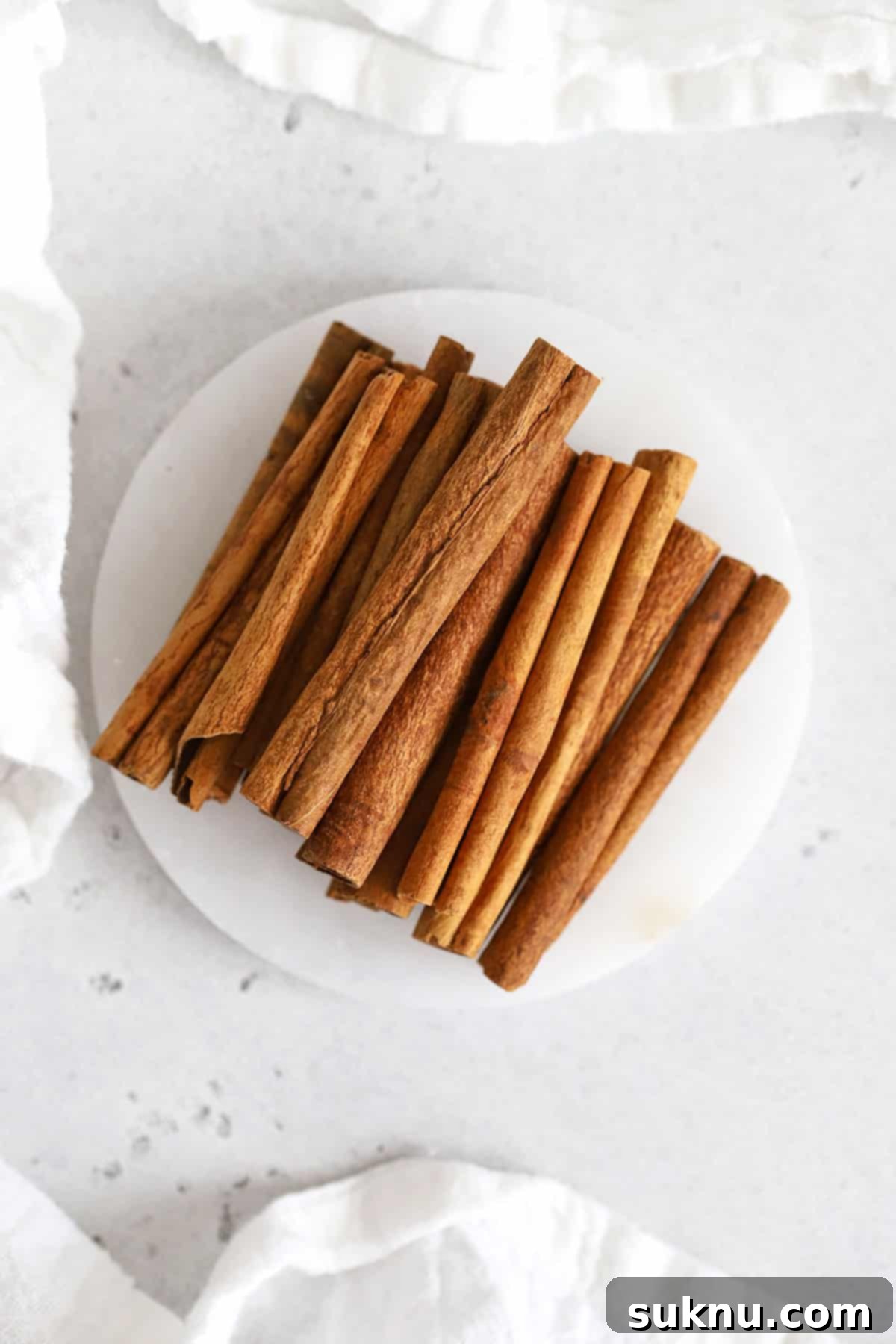 overhead view of cinnamon sticks on a white coaster