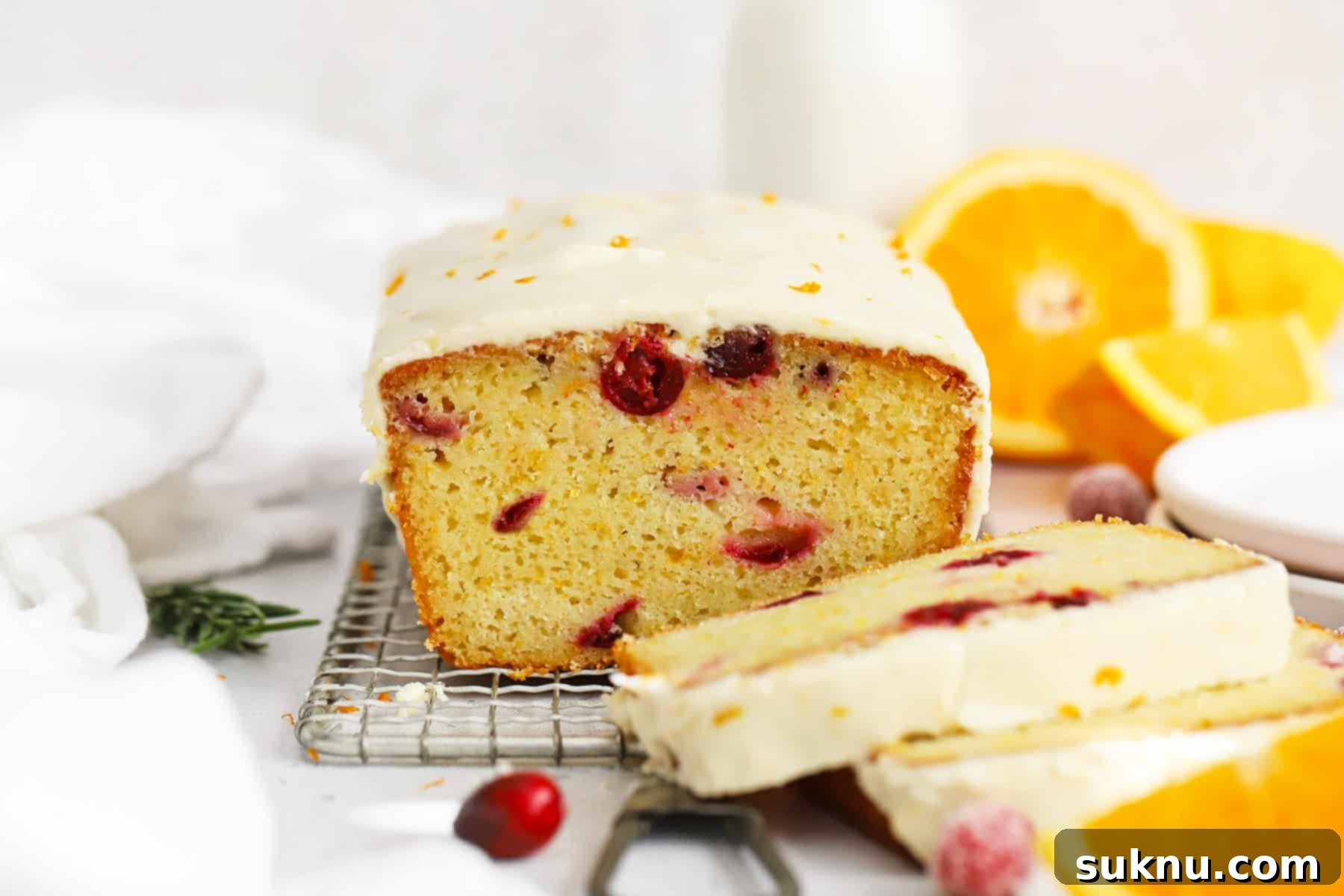 Front view of gluten-free orange cranberry loaf cake sliced, so you can see the soft, fluffy texture inside