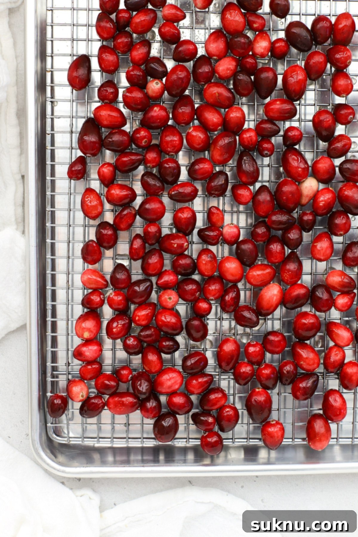 Sparkling Sugared Cranberries 7 Cranberries coated with simple syrup cooling on a drying rack