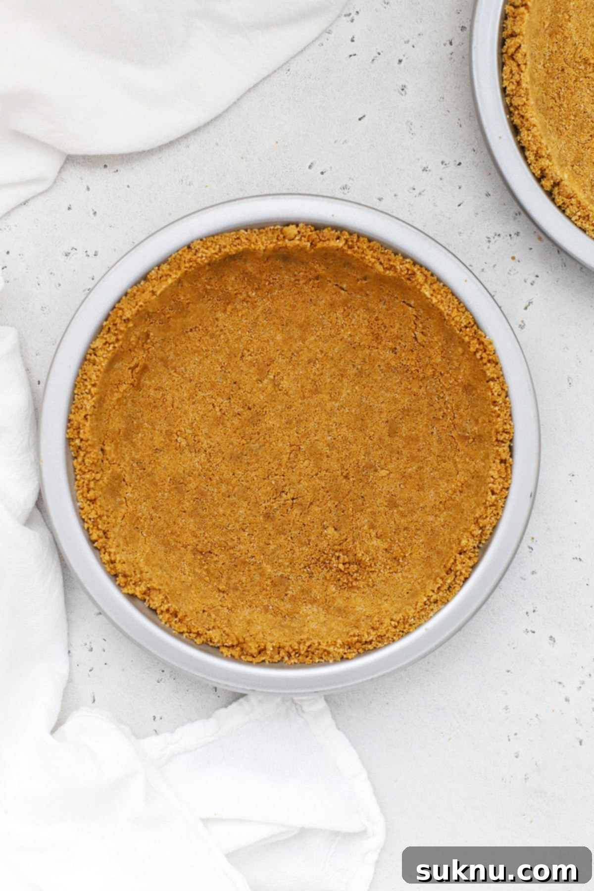 Perfectly baked gluten-free graham cracker crust in a metal pie plate, ready for filling
