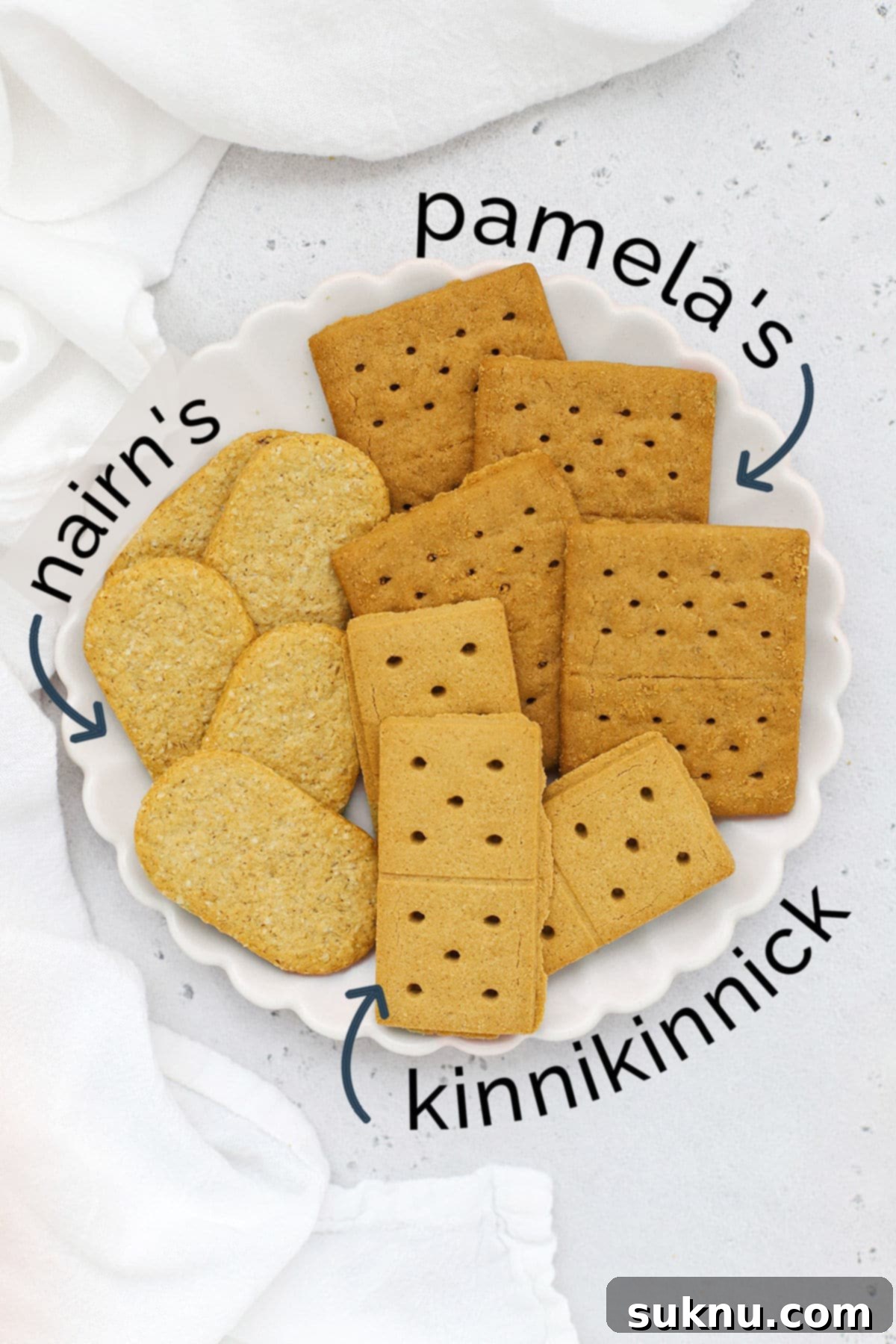 Overhead view of three different brands of gluten-free graham crackers on a white scallop plate, highlighting variety