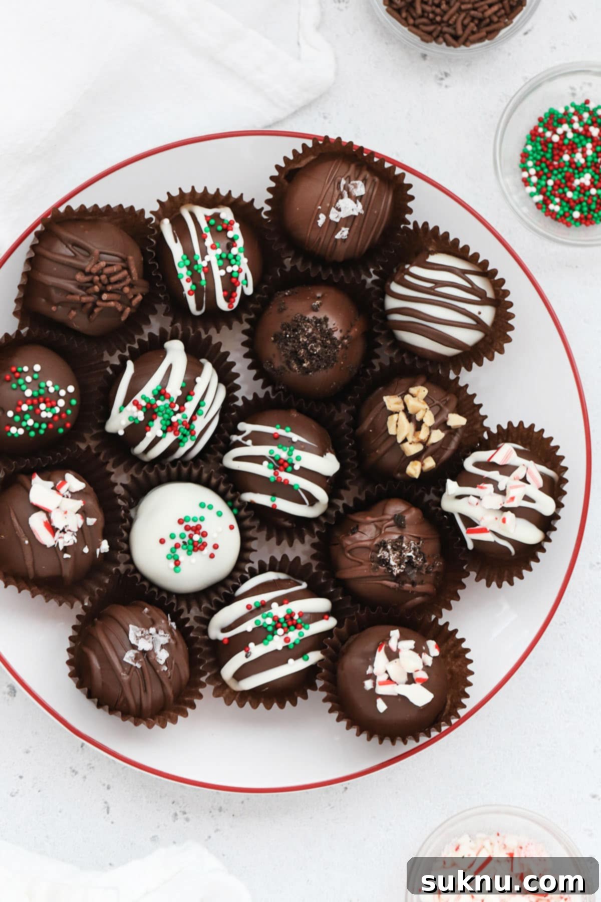 Decadent Gluten-Free Oreo Truffles 6 Gluten-free Oreo truffles decorated with different toppings on a white plate with a red rim