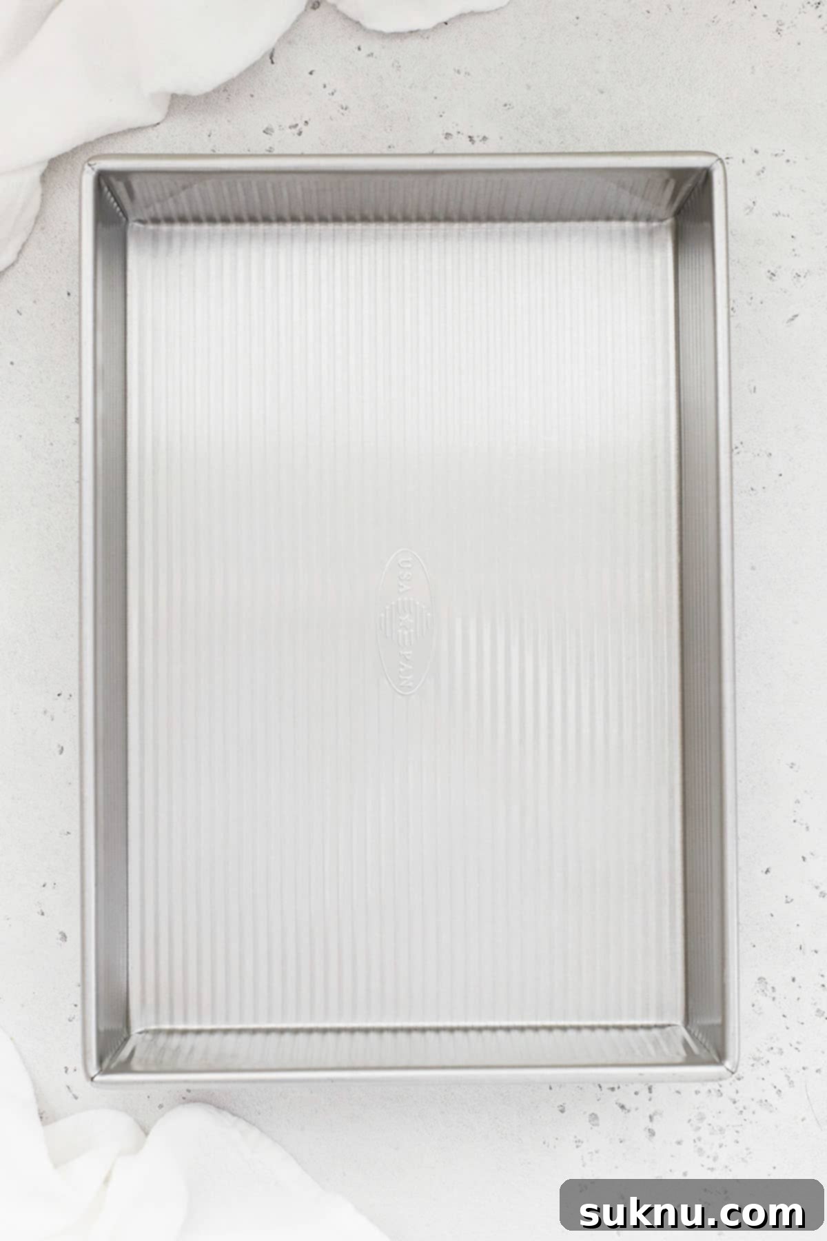 A pristine 9x13 inch light-colored metal baking pan, ready for a large batch of delicious baked goods.