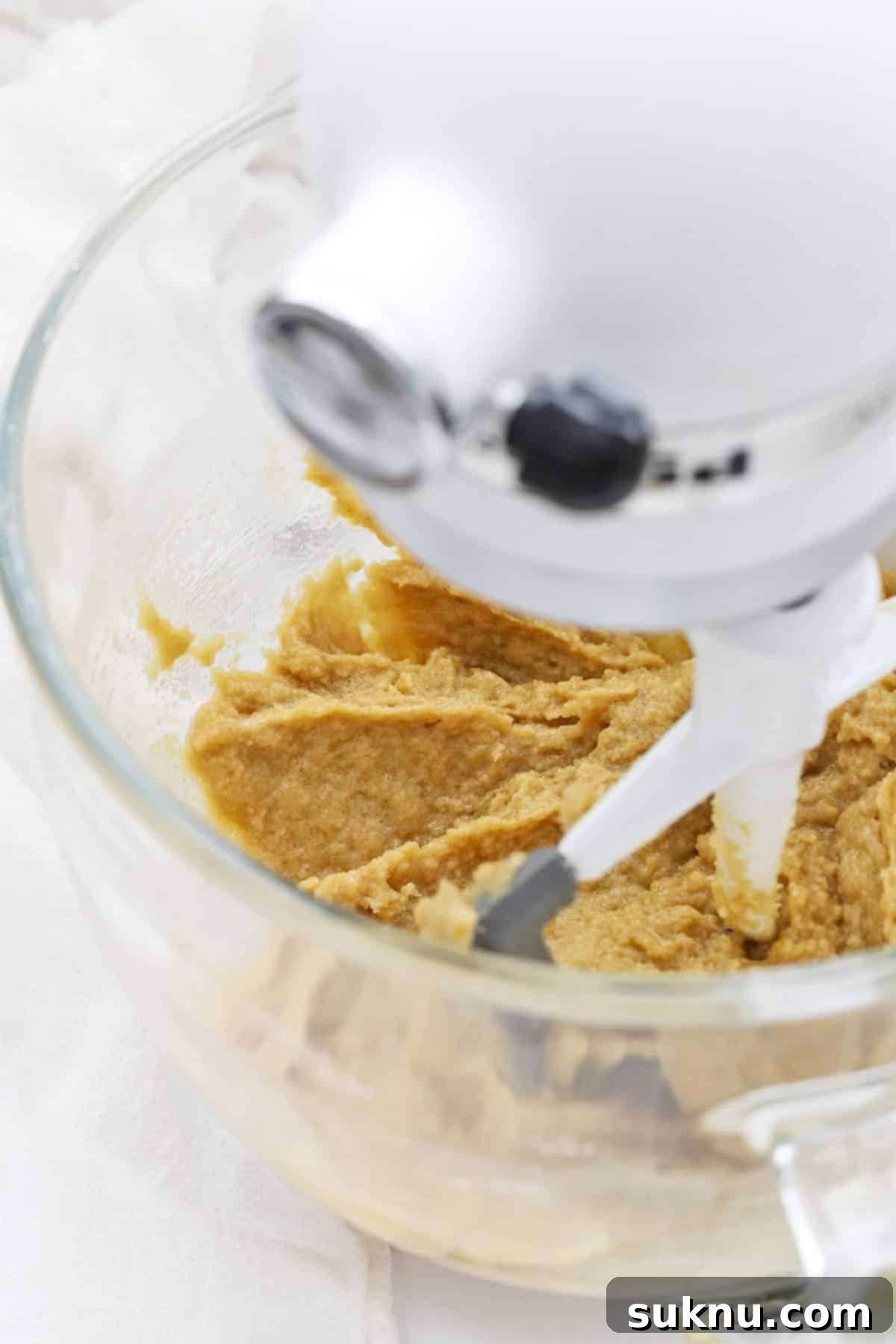 The process of creaming softened butter, sugars, eggs, and vanilla extract together in a mixer
