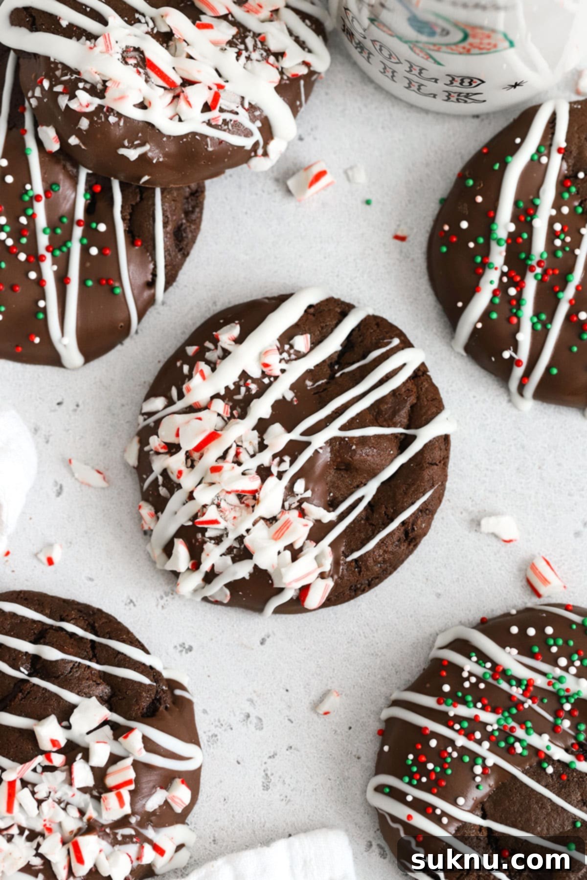 Gluten-free chocolate candy cane cookies on a white background, dusted with powdered sugar and crushed peppermint