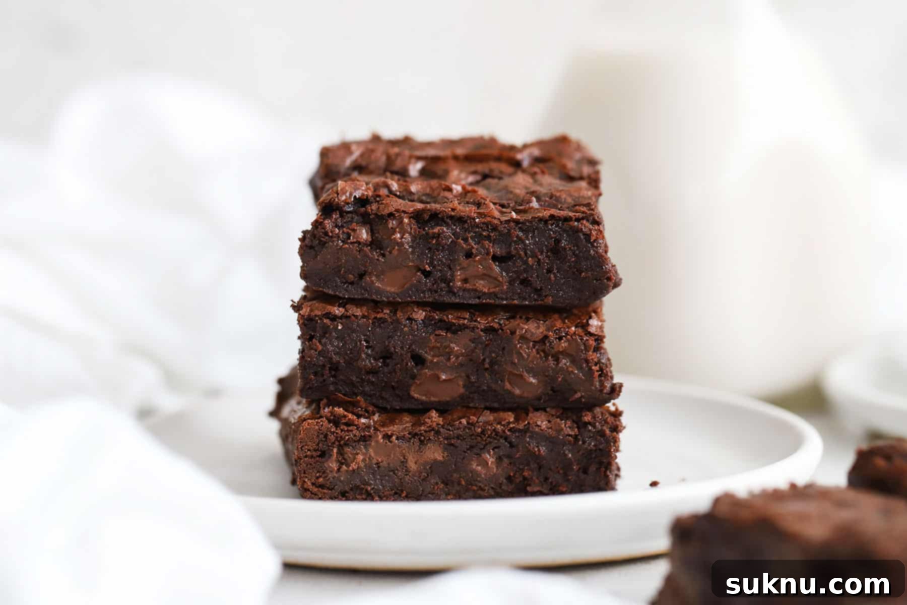Decadent Fudgy Gluten-Free Vegan Brownies 7 three fudgy gluten-free vegan brownies stacked on a white plate