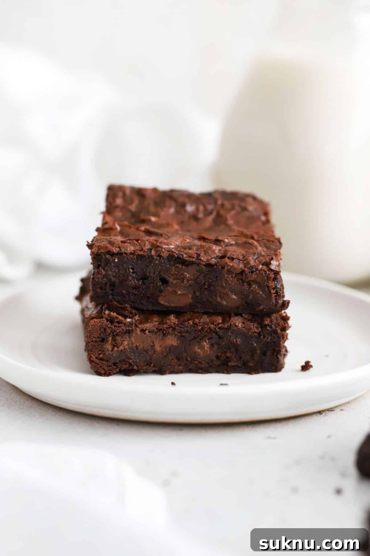 Decadent Fudgy Gluten-Free Vegan Brownies 6 two fudgy gluten-free vegan brownies stacked on a white plate, showcasing their rich texture