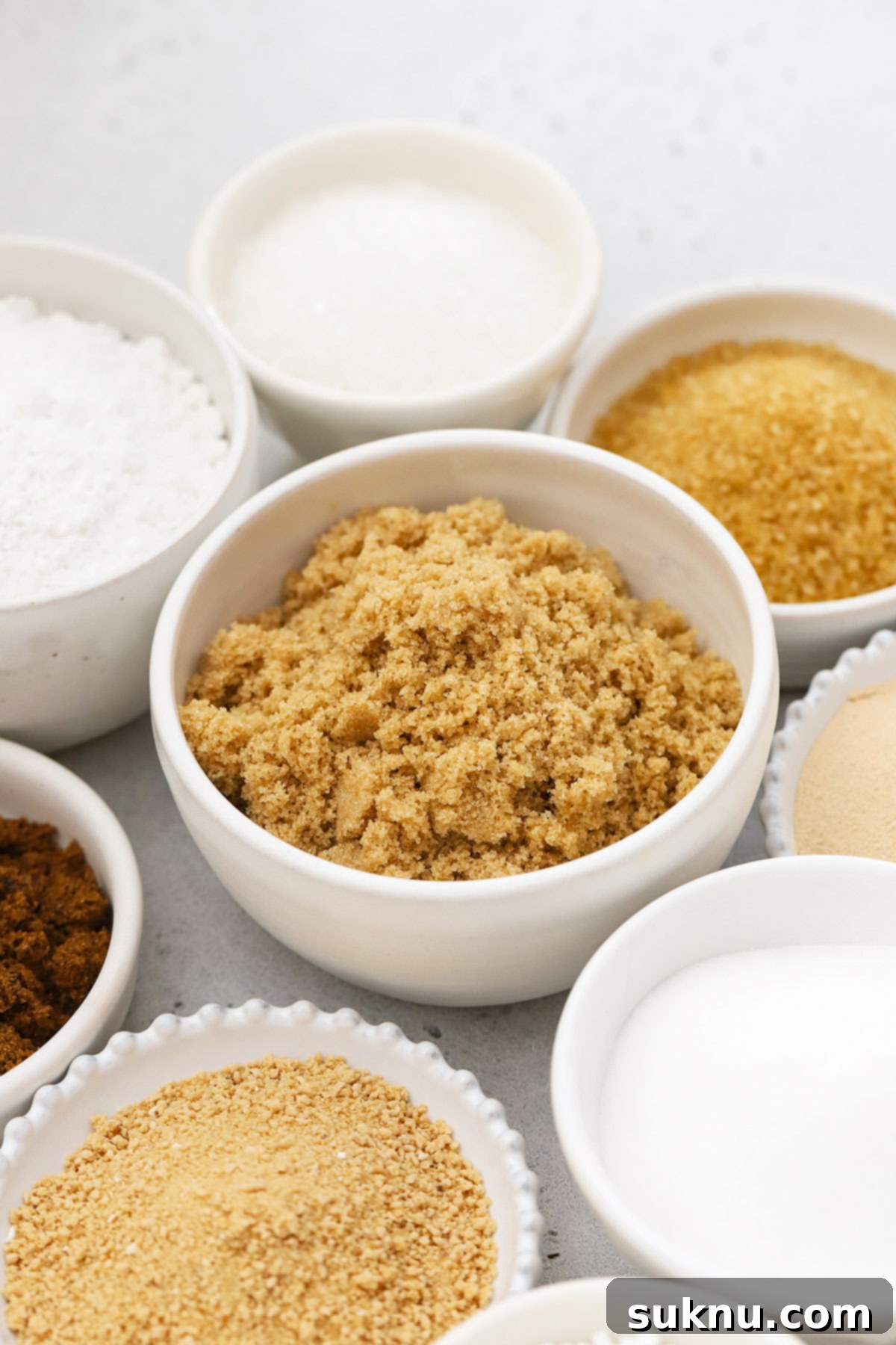 Mastering Sweetness: 12 Sugar Types and Their Culinary Applications 15 different kinds of sugar in small white bowls