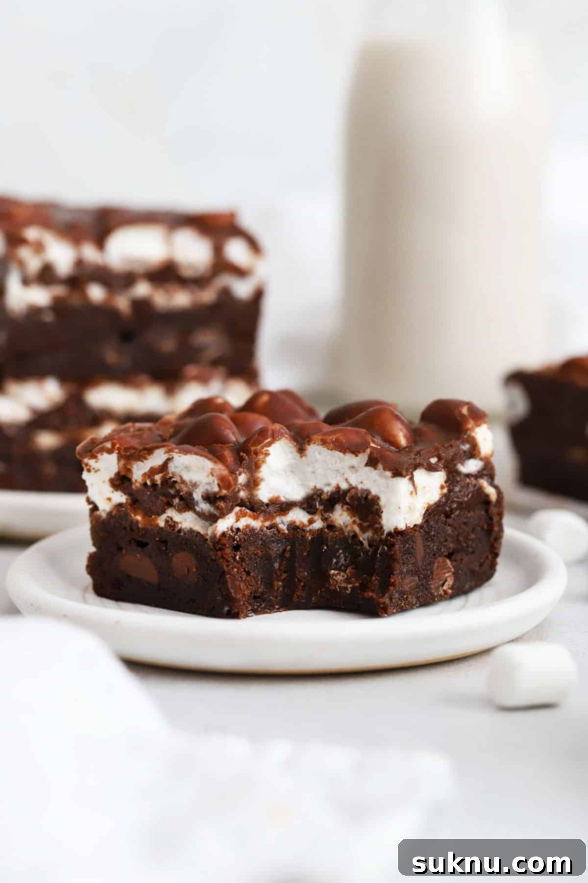 Gooey Gluten-Free Marshmallow Brownies 8 a gluten-free marshmallow brownie on a plate with a bite taken out of it