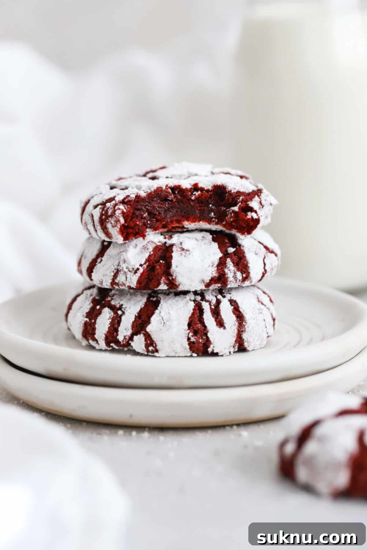 Irresistible Gluten-Free Red Velvet Crinkle Cookies 5 red velvet crinkle cookies stacked on white plates