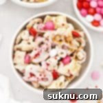 Gluten-free Valentines Chex Mix with red, white, and pink m&ms in a white bowl, featured in recipe card