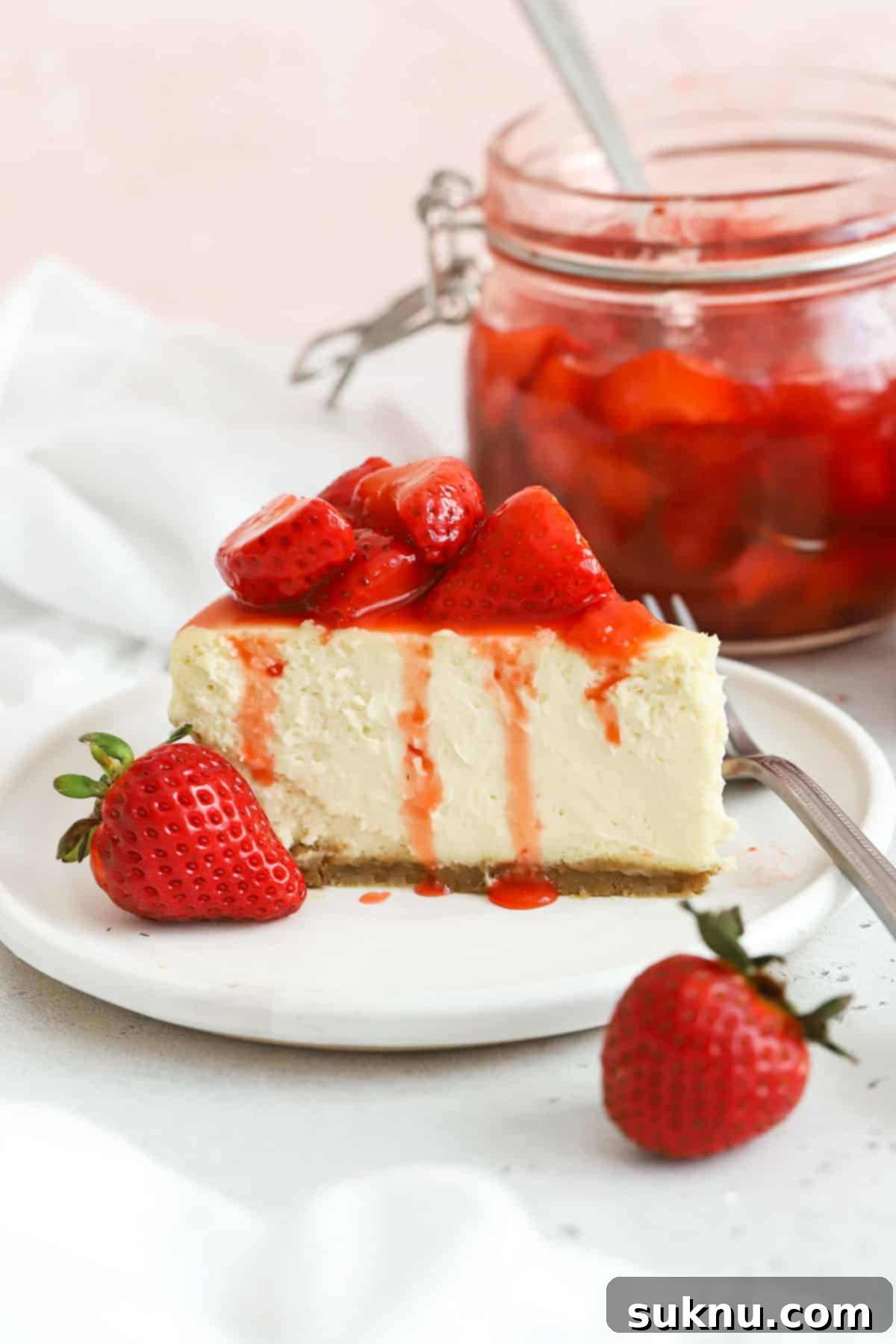 Gluten-free strawberry cheesecake topped with strawberry sauce, ready to be served