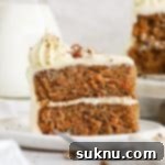 Moist Gluten Free Carrot Cake 12 A slice of gluten-free carrot layer cake on a white plate with a fork.