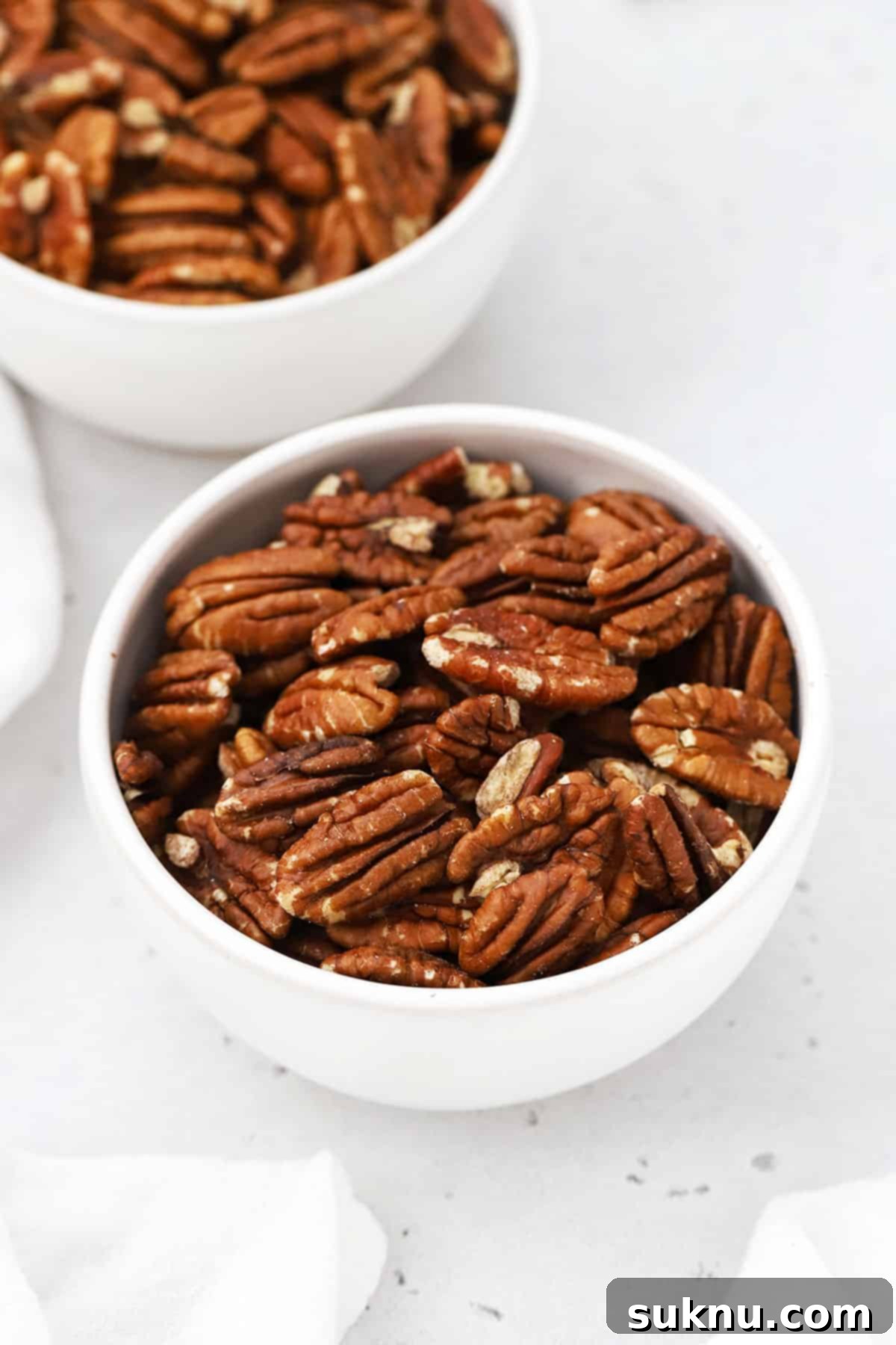Close-up of toasted pecans in bowls, showing their golden color and inviting texture