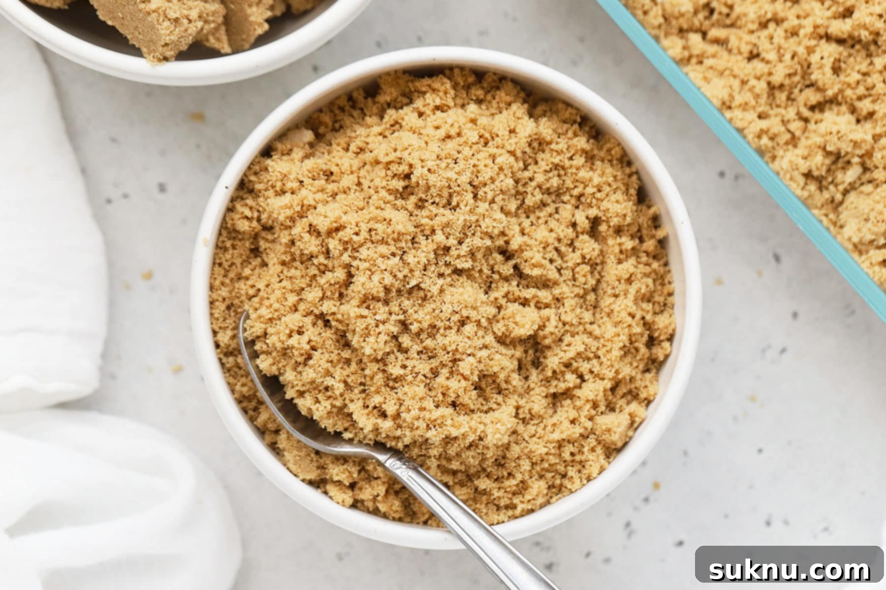 Revive Your Hard Brown Sugar 15 A bowl of softened brown sugar on a white background, perfectly fluffy and ready for baking.