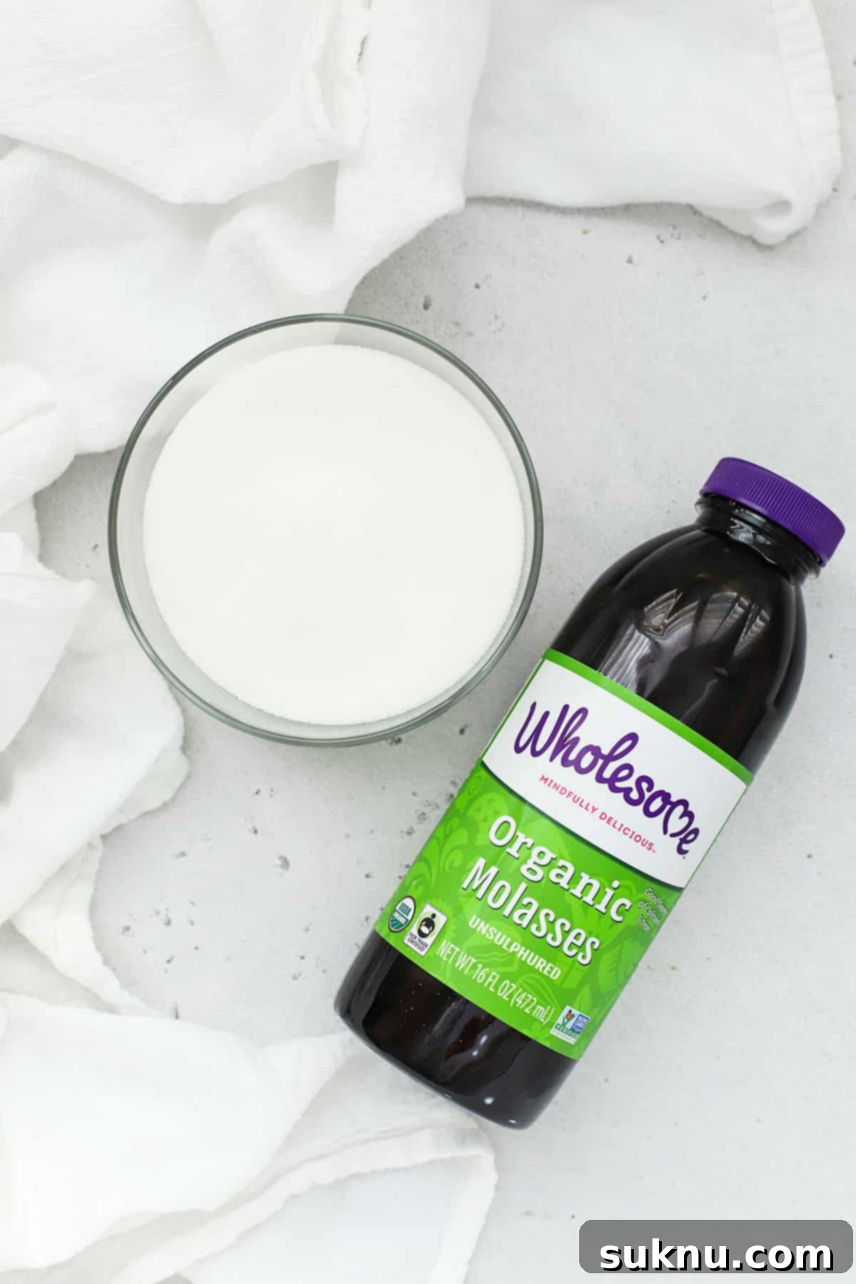 Ingredients for brown sugar: a bowl of white sugar and a bottle of molasses