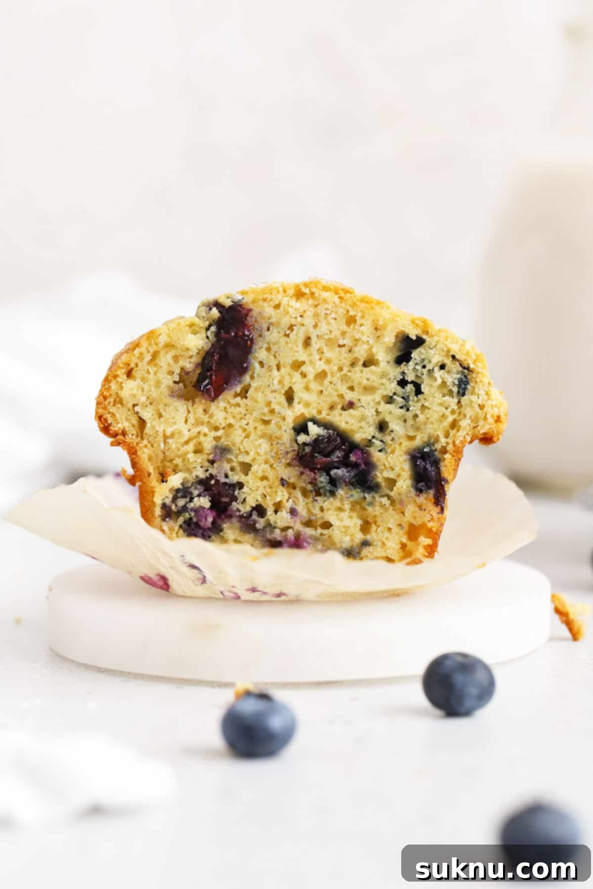gluten-free blueberry muffin cut in half to reveal a fluffy texture