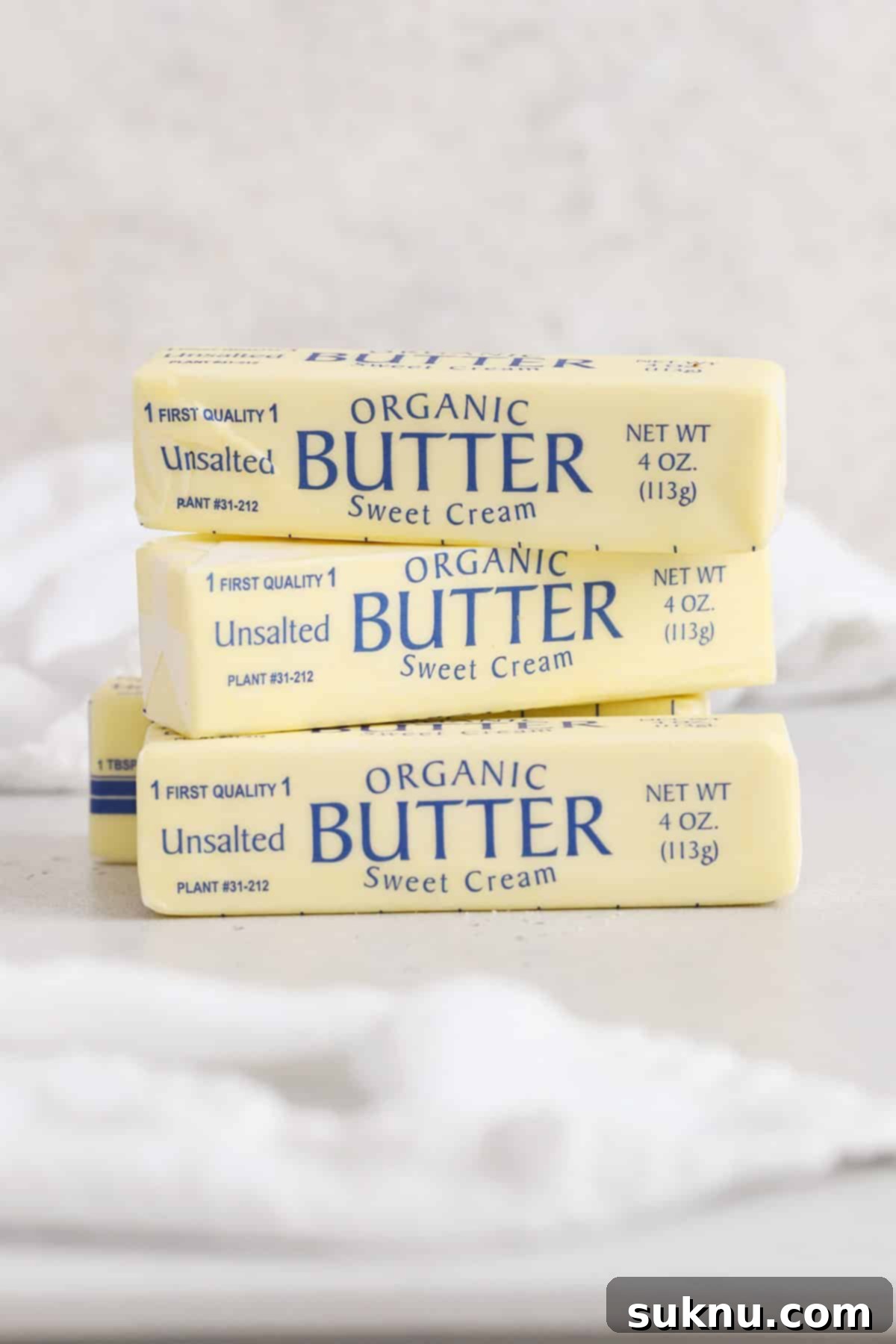 Demystifying Butter Measurement: Sticks, Tablespoons, and More 2 Four sticks of butter stacked neatly on a clean white background, highlighting their standard size and packaging.