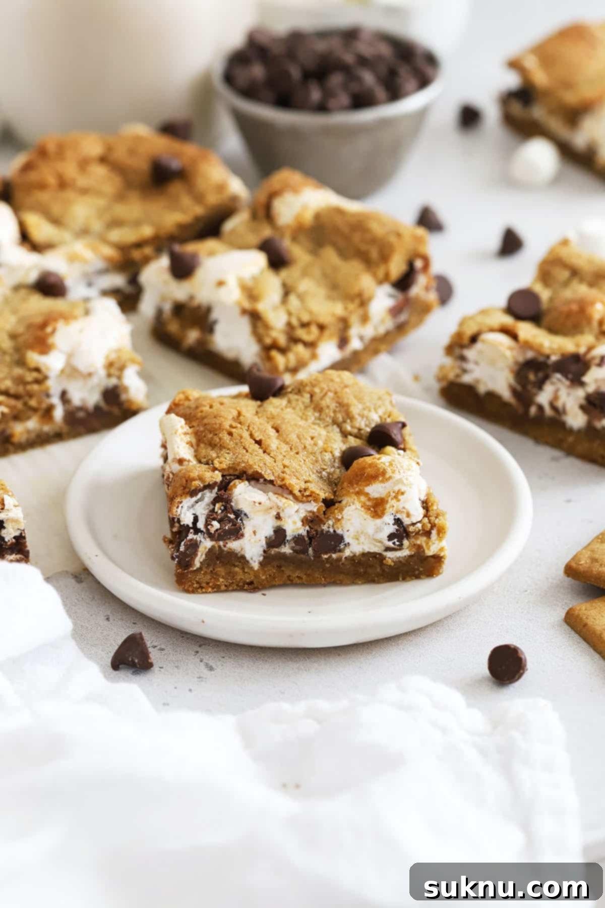 Gluten-free s'mores cookie bars cut into perfect squares, showing the distinct layers of graham cookie, marshmallow, and chocolate.
