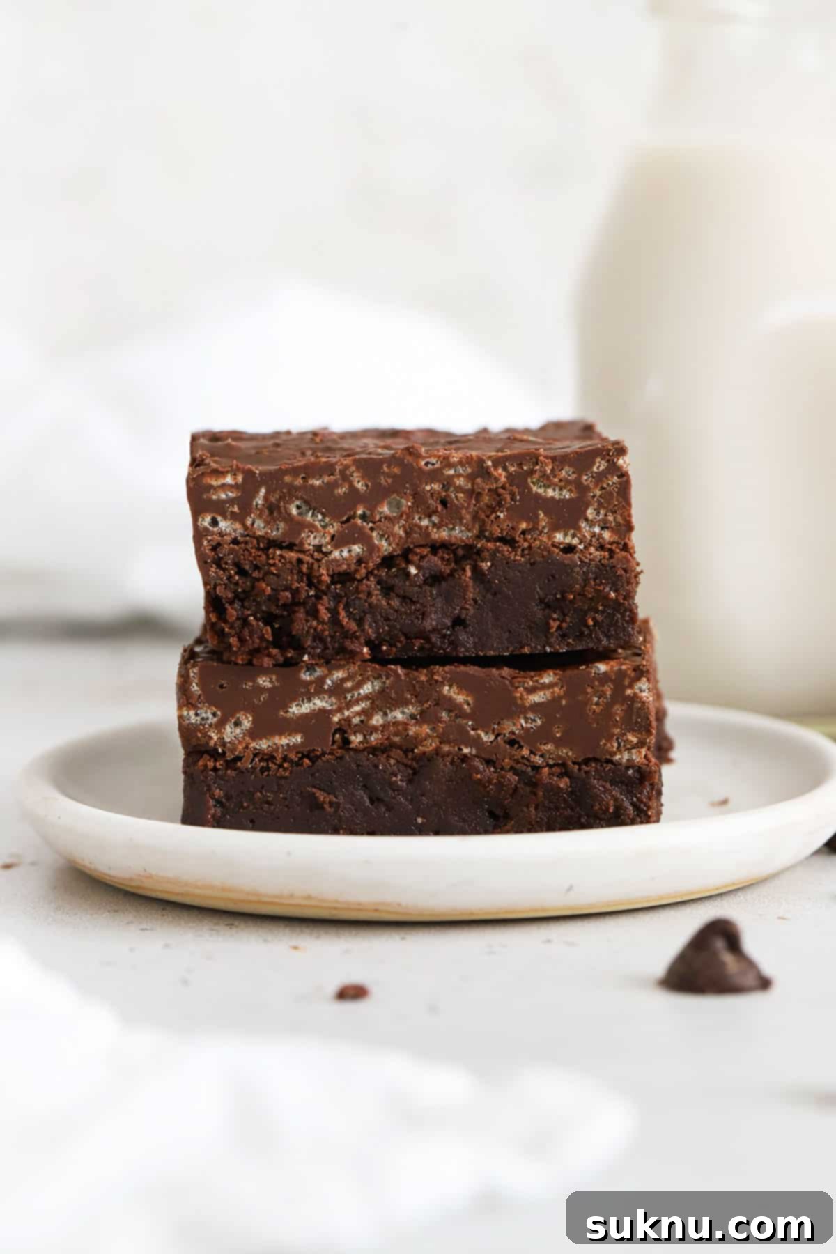 Gluten Free Crunchy Brownies 2 Two fudgy gluten-free crunch brownies with chocolate crisp topping on a white plate, ready to be enjoyed.