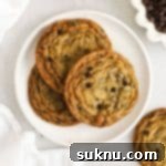 Ultimate Thin and Crispy Gluten-Free Chocolate Chip Cookies 10 Three crisp gluten-free chocolate chip cookies on a white plate, perfectly golden