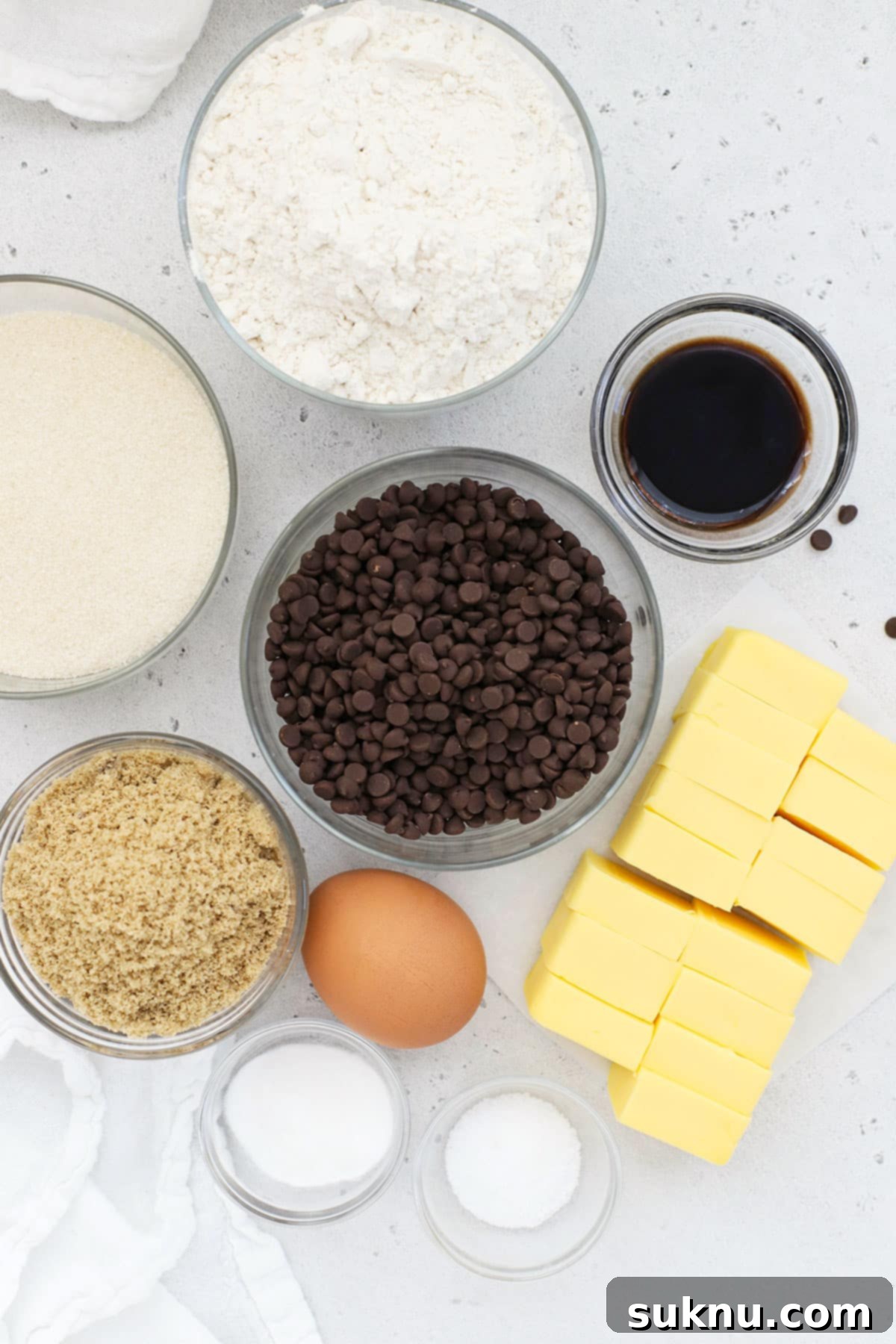 Ultimate Thin and Crispy Gluten-Free Chocolate Chip Cookies 4 Ingredients for making crispy gluten free chocolate chip cookies laid out on a white surface