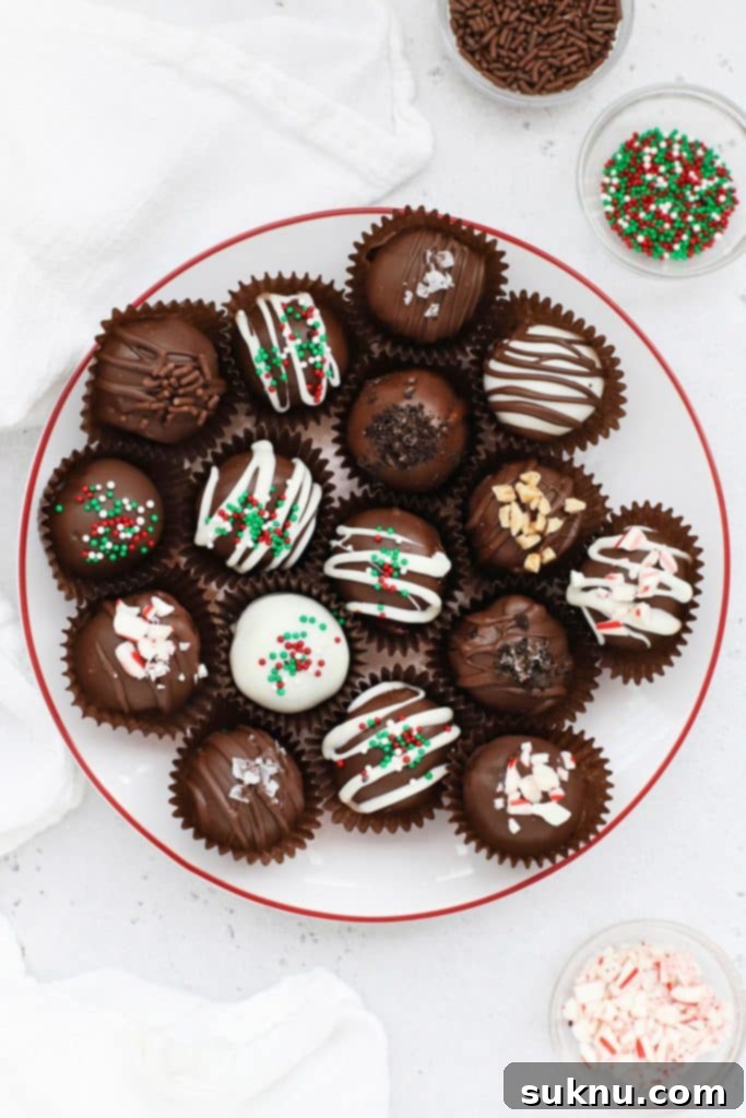 Gluten-free Oreo truffles decorated with different toppings on a white plate with a red rim, perfect for a festive occasion.