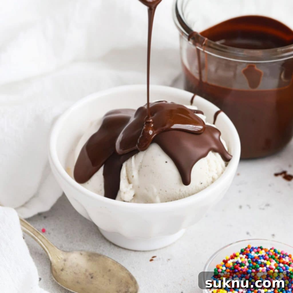 Chocolate shell being poured over vanilla ice cream, creating a magic hard coating.