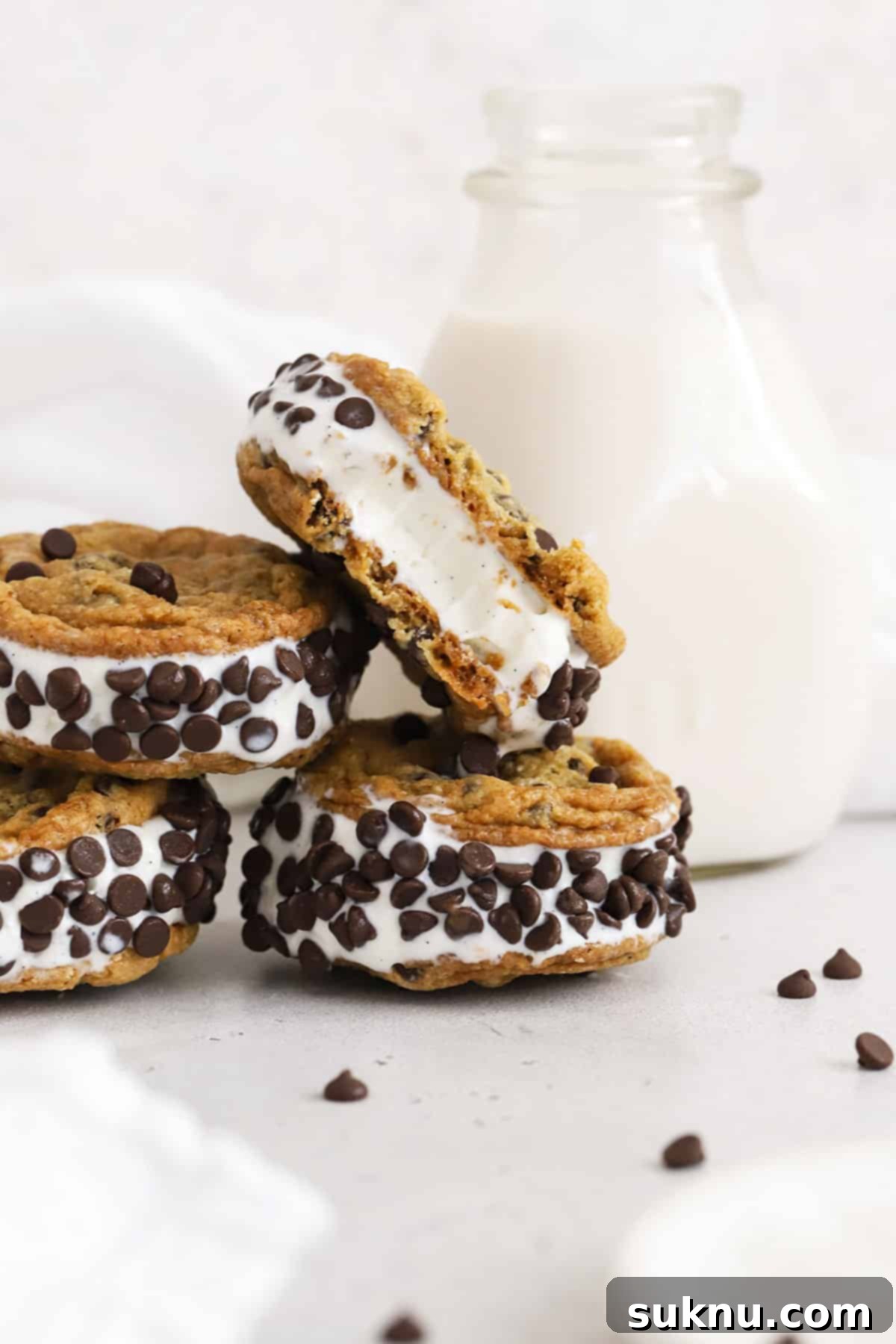 Gluten-free chocolate chip cookie ice cream sandwiches beautifully stacked on a clean white background.
