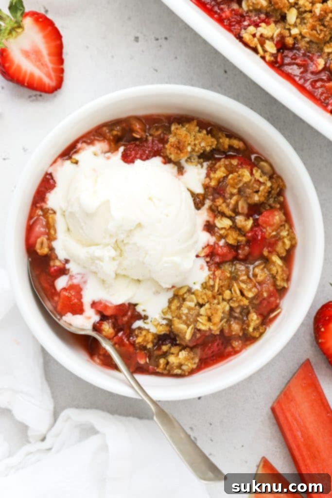 Gluten Free Strawberry Crumble 10 A bowl of gluten-free strawberry rhubarb crisp topped with a scoop of vanilla ice cream