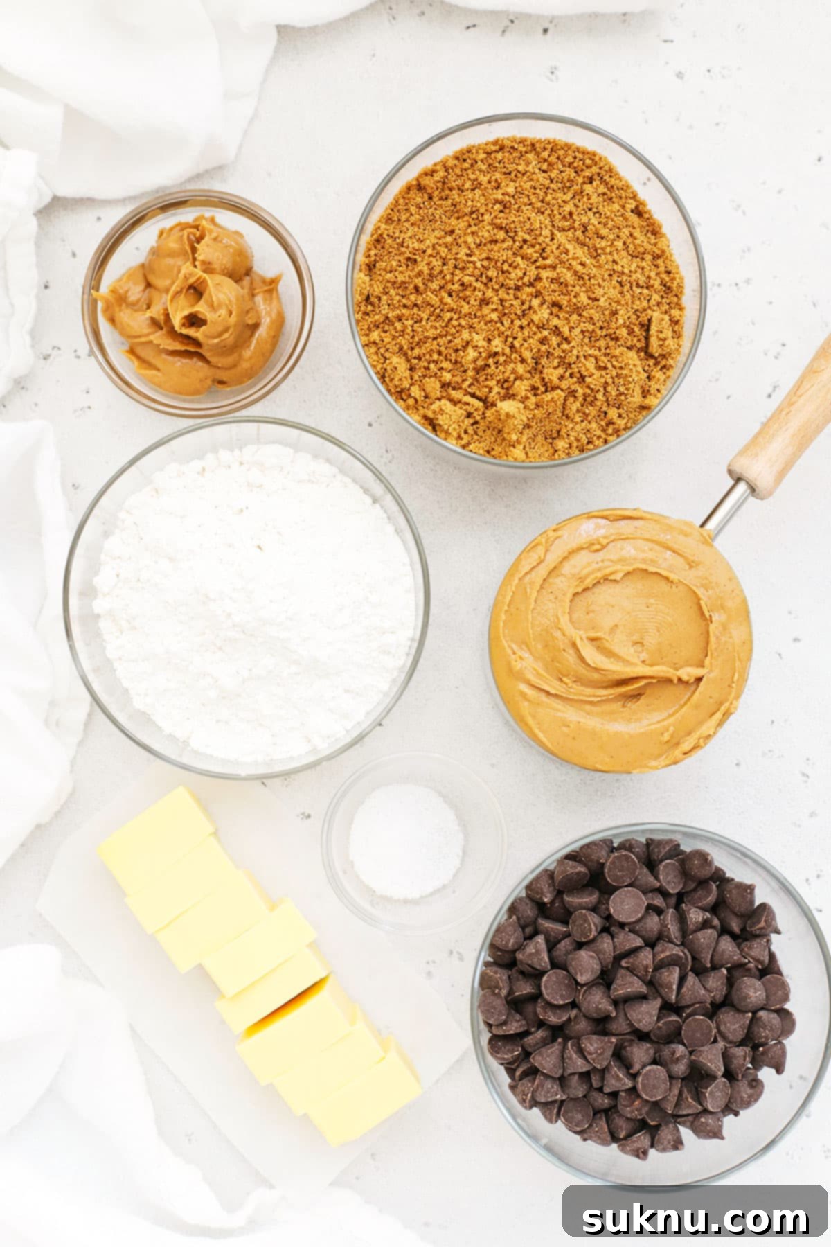 Collection of ingredients for gluten-free chocolate peanut butter bars laid out on a white surface