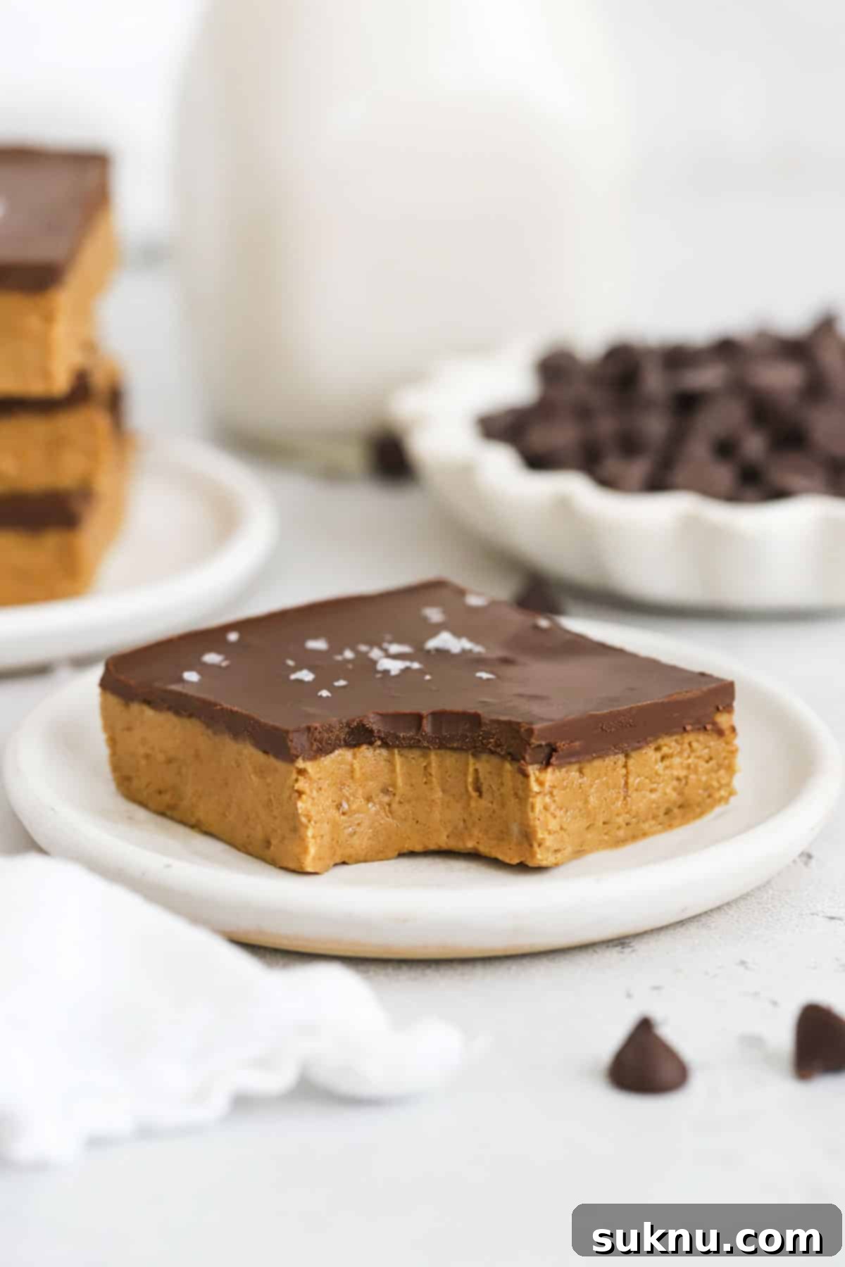 Close-up of a gluten-free chocolate peanut butter bar with a bite taken out, showing the creamy texture