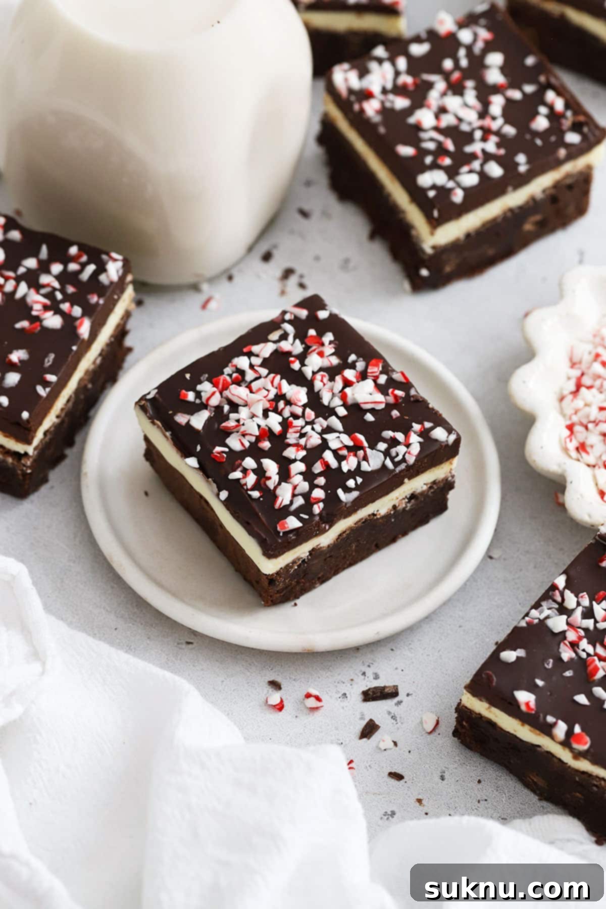 Festive Gluten-Free Peppermint Crunch Brownies 2 gluten-free peppermint crunch brownies cut into squares, showcasing distinct layers