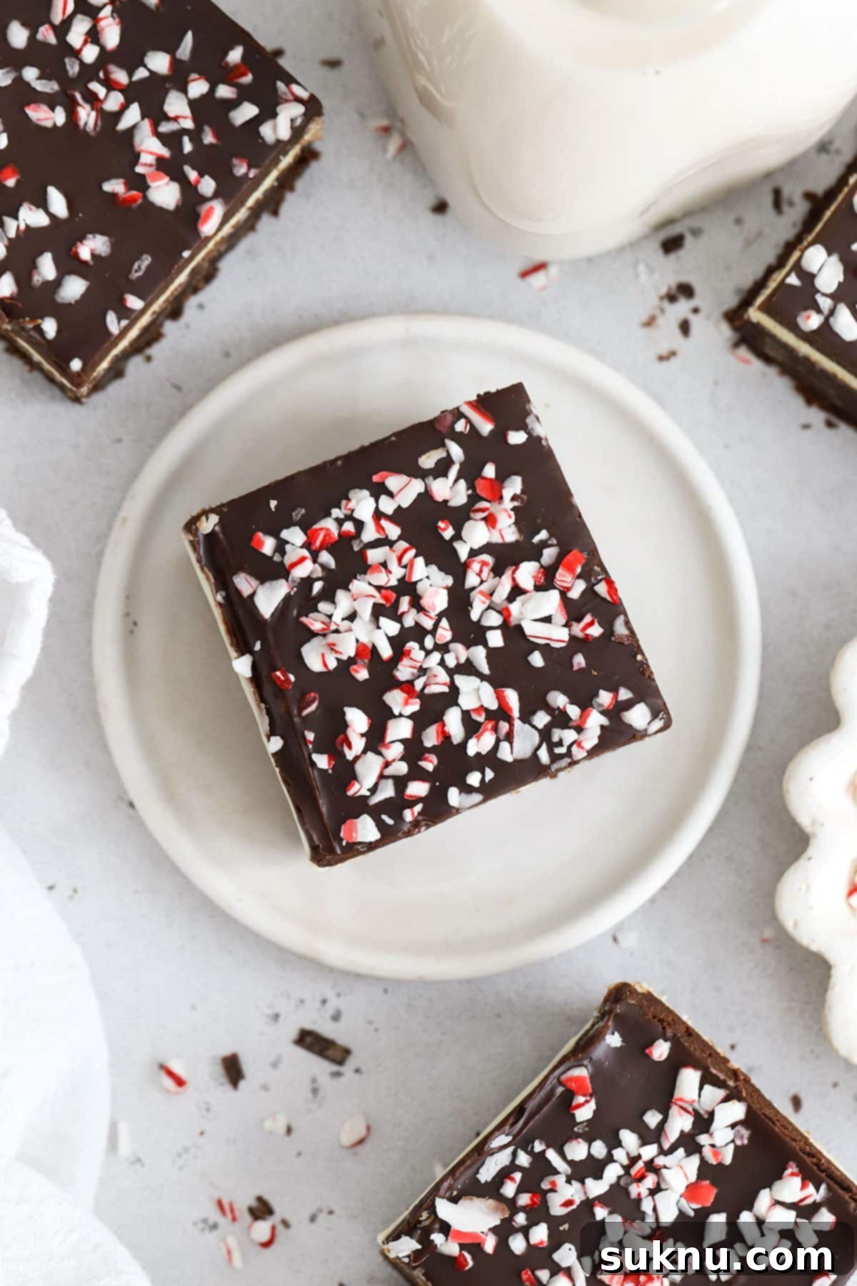 Festive Gluten-Free Peppermint Crunch Brownies 7 squares of gluten-free peppermint brownie on a white background, highlighting layers
