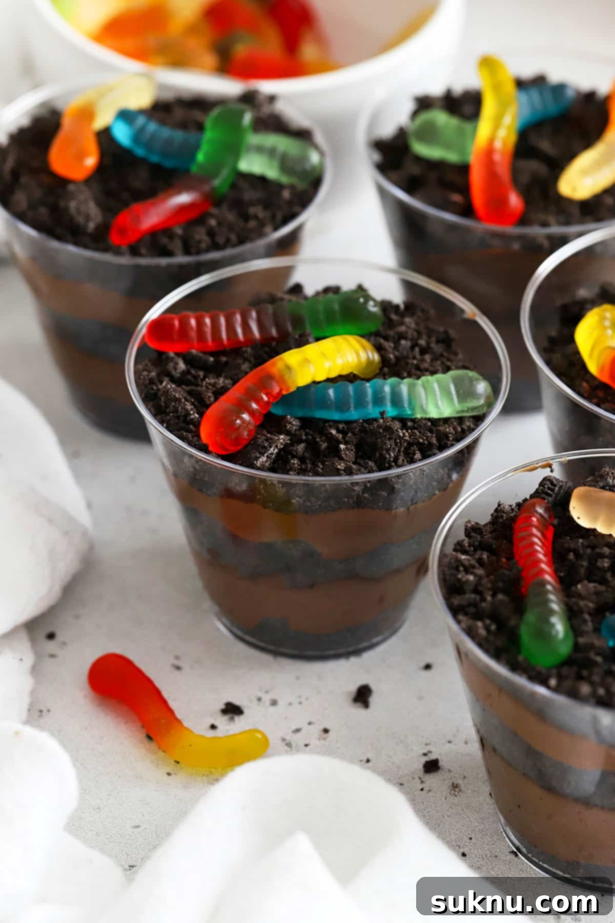 Gluten-free dirt pudding cups with vibrant gummy worms, a classic childhood dessert reimagined.