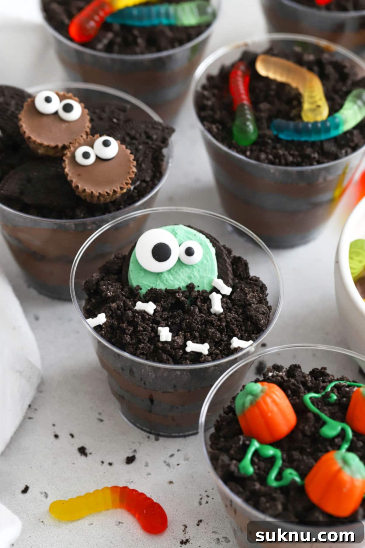 A comprehensive collection of gluten-free Halloween dirt pudding creations, featuring an assortment of adorable bat, monster, and pumpkin designs, highlighting diverse decorating options.