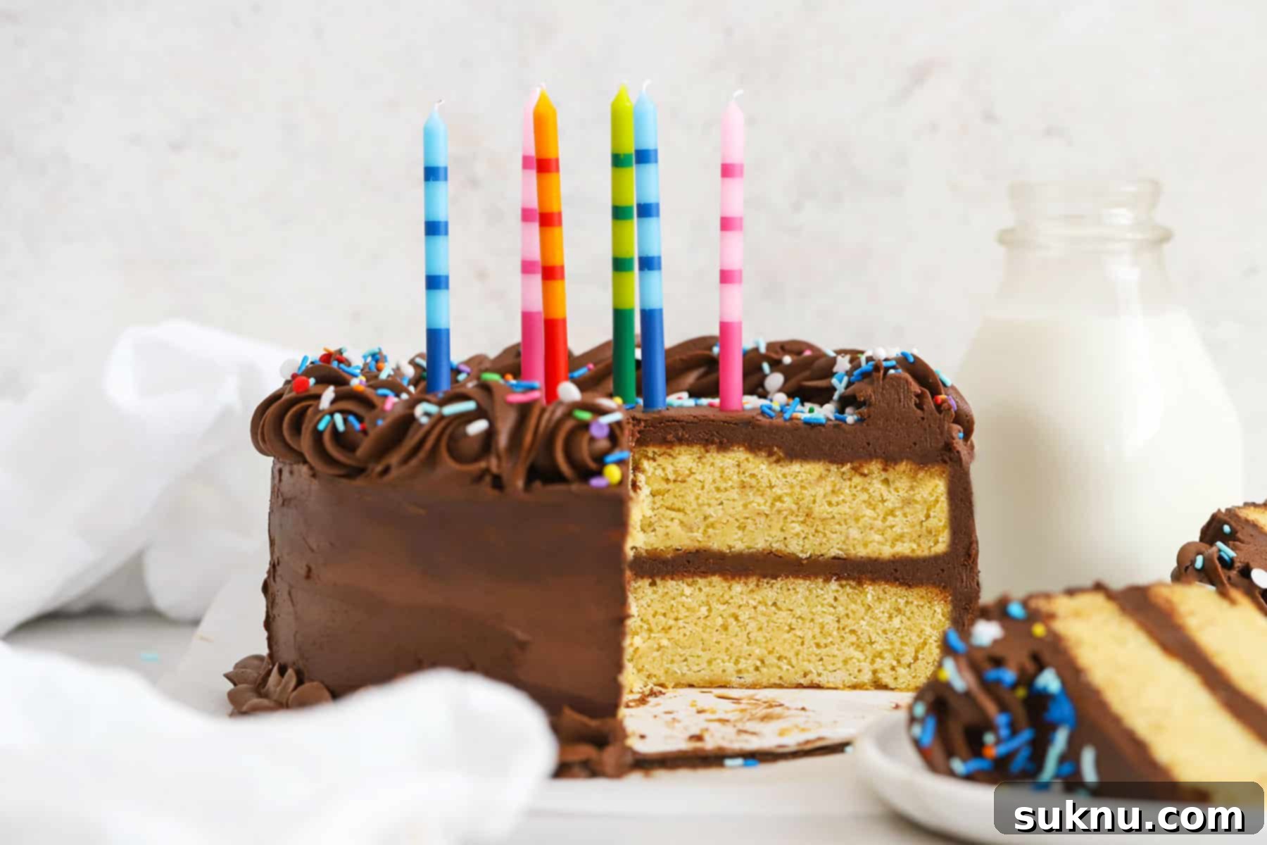 Classic Gluten-Free Yellow Birthday Cake 9 Gluten-free yellow cake with chocolate frosting, colorful sprinkles, and colorful striped birthday candles