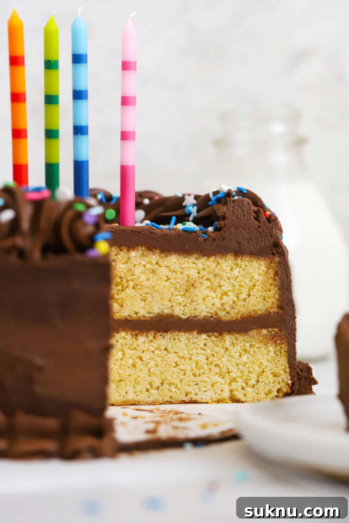 Classic Gluten-Free Yellow Birthday Cake 7 Gluten-free yellow cake with chocolate frosting, colorful sprinkles, and colorful striped birthday candles