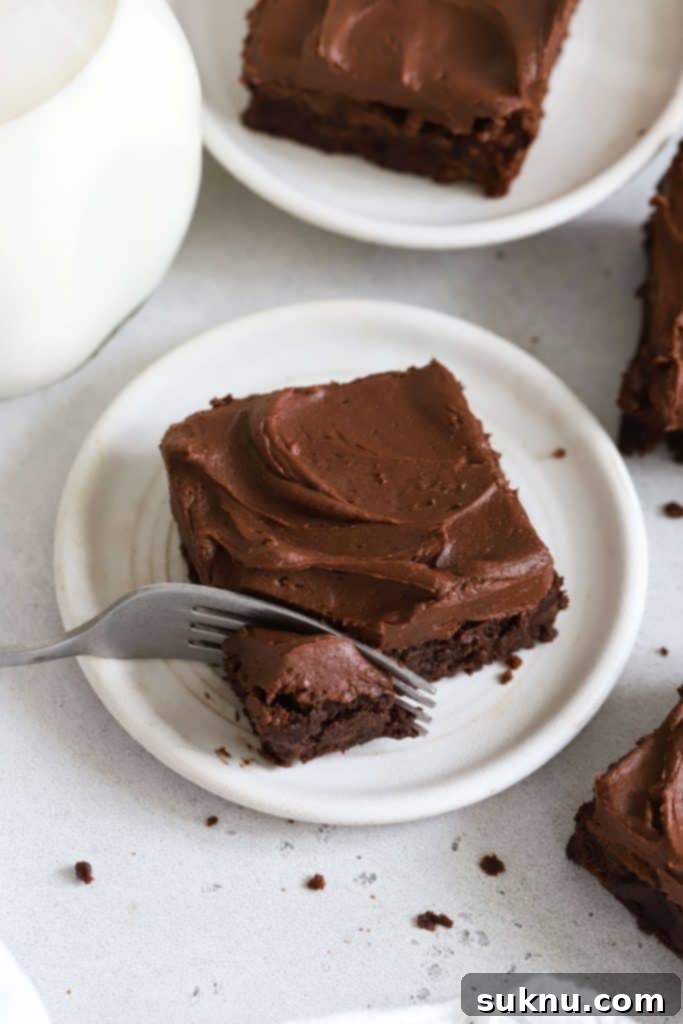 Decadent Gluten-Free Chocolate Buttercream 9 using a fork to take a bite out of a frosted gluten-free brownie