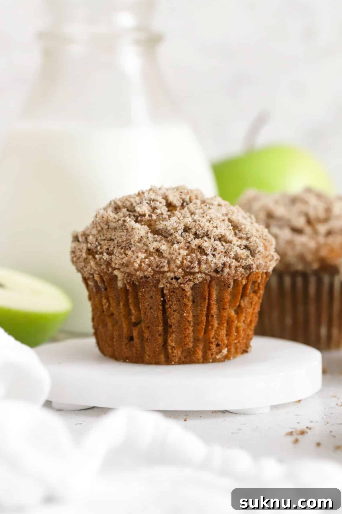 Delicious gluten-free apple muffins topped with a sweet cinnamon-sugar mixture, ready for a cozy breakfast.