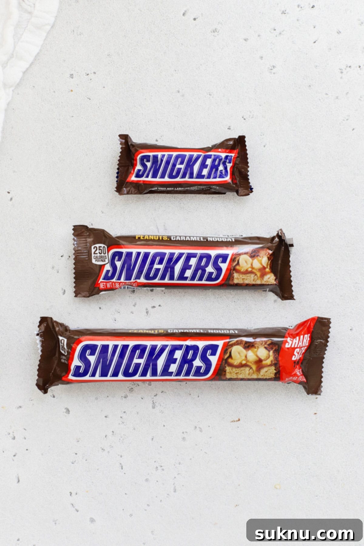 three different sizes of Snickers candy bars