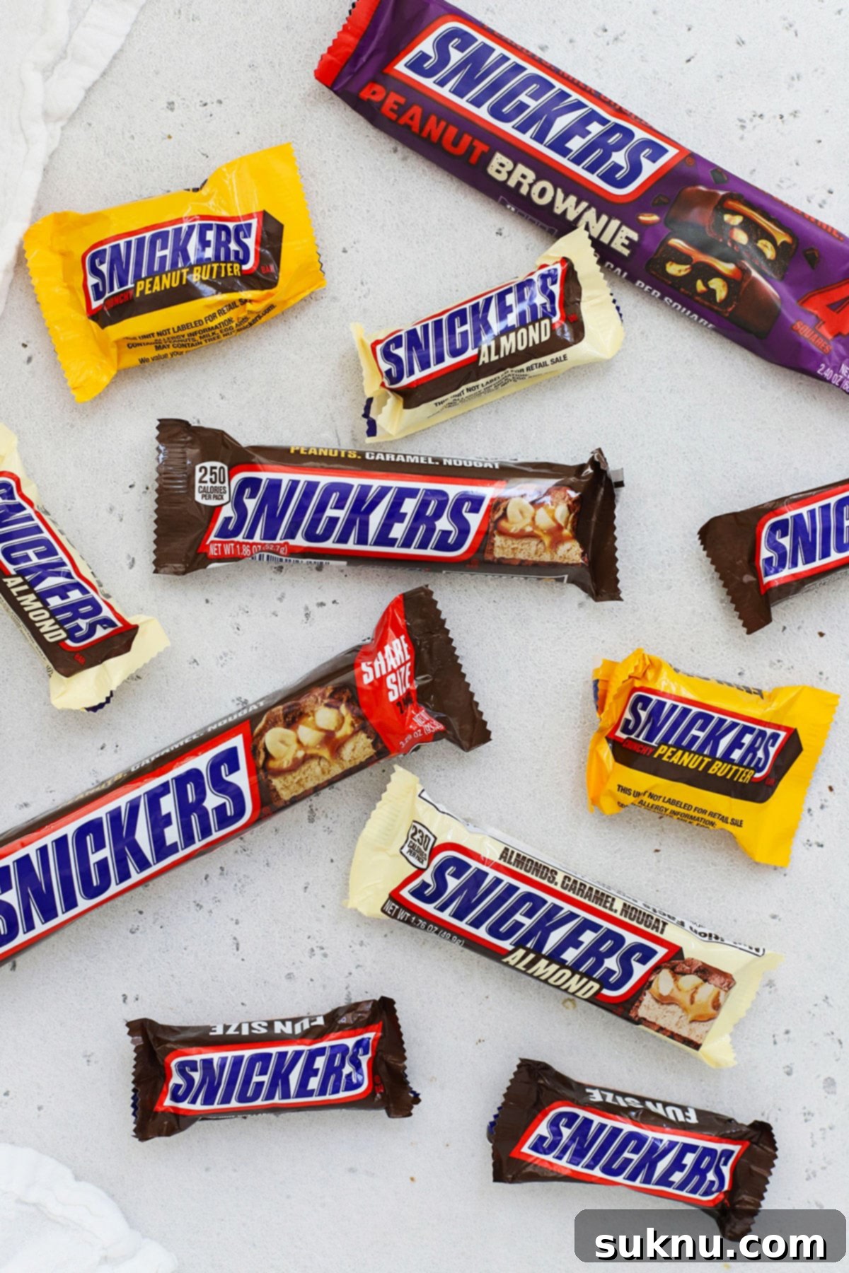 different flavors of Snickers bars arranged on a white background