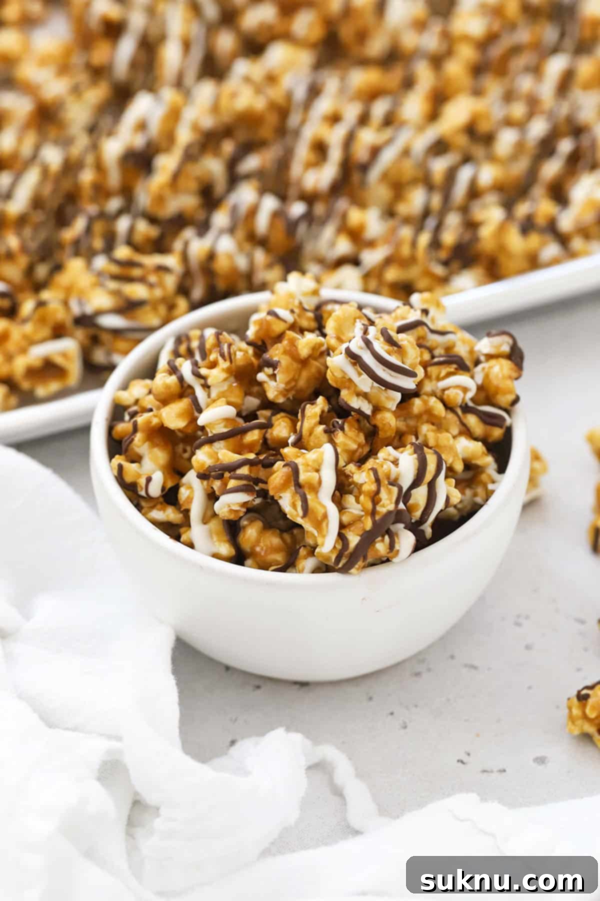 Swirled Zebra Popcorn 2 white bowl filled with zebra popcorn drizzled with white chocolate and dark chocolate