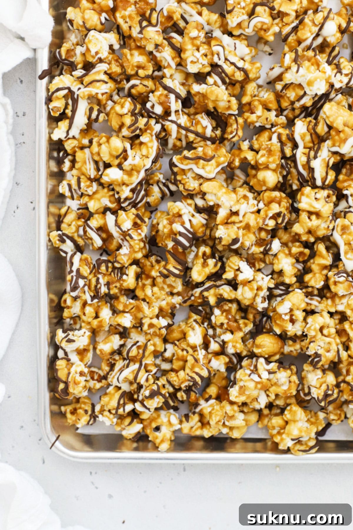 Swirled Zebra Popcorn 3 a sheet pan of zebra caramel corn drizzled with white and dark chocolate stripes