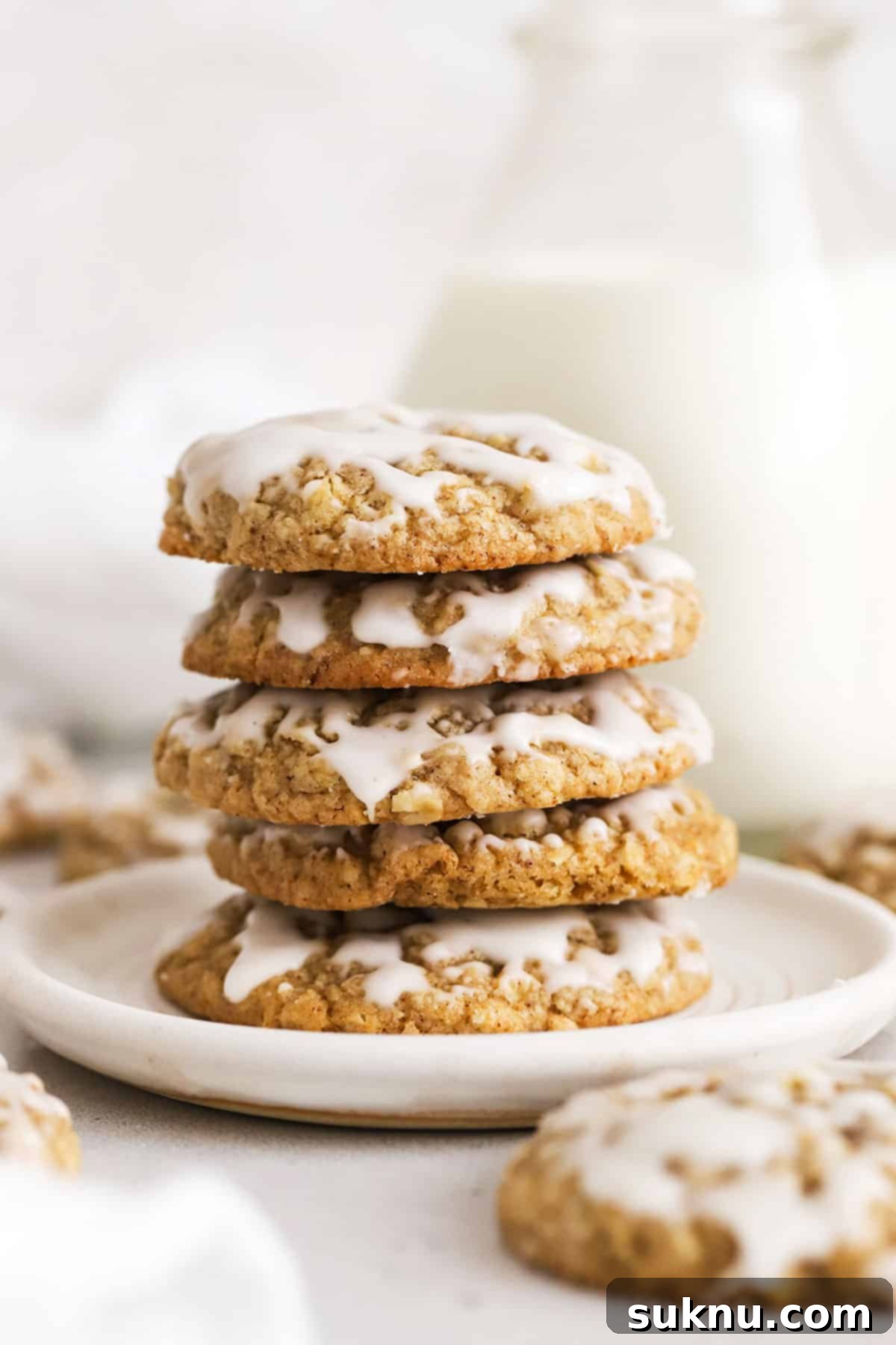 Stack of gluten-free brown butter iced oatmeal cookies on a white plate