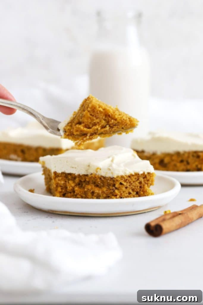 A fork getting a bite of gluten-free pumpkin bars with whipped cream cheese frosting