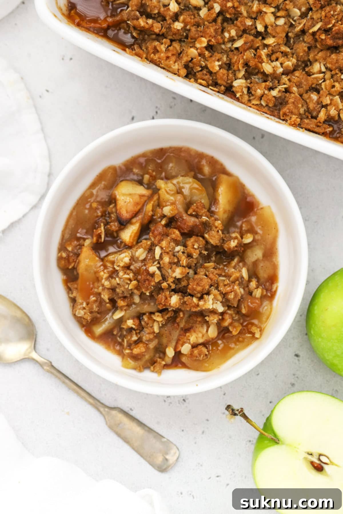 Decadent Gluten-Free Caramel Apple Crisp 6 A bowl of warm apple crisp with caramel sauce and ice cream, ready to enjoy.