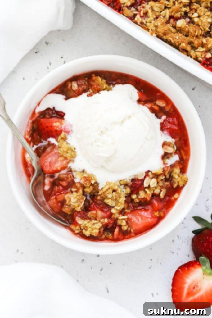 Decadent Gluten-Free Caramel Apple Crisp 8 Gluten-free strawberry crisp in a white bowl topped with vanilla ice cream.