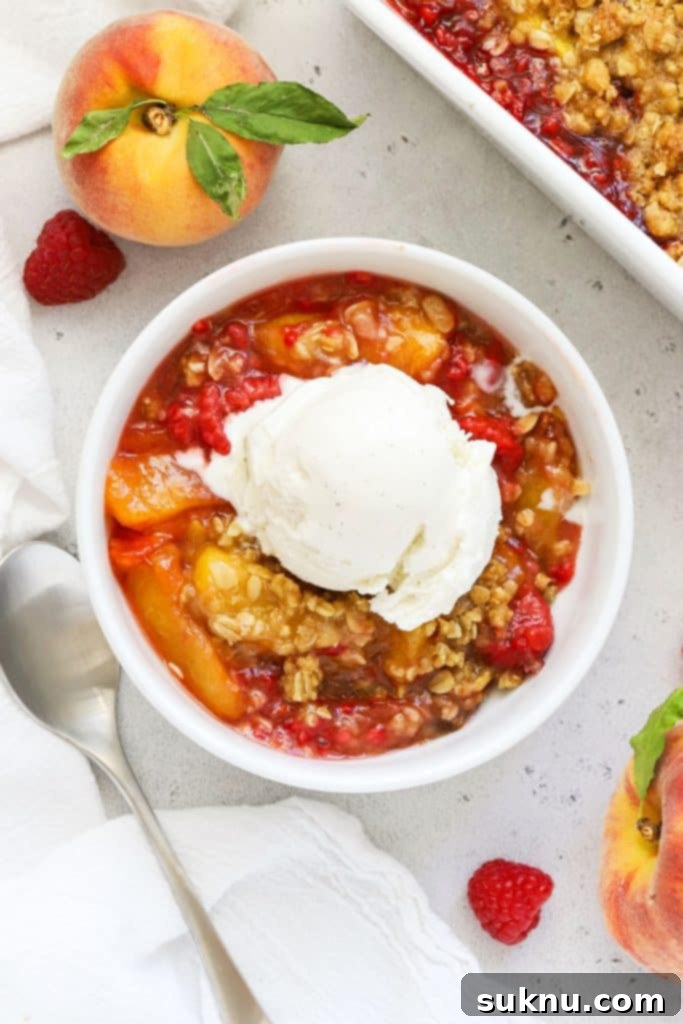 Decadent Gluten-Free Caramel Apple Crisp 10 A bowl of gluten-free raspberry peach crisp topped with vanilla ice cream.